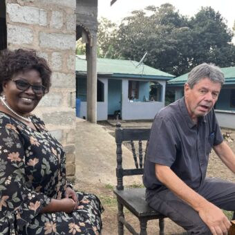 Zittende reiziger op bezoek bij een Tanzaniaanse vrouw tijdens de rondreis door Tanzania