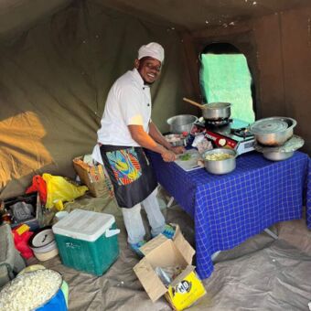 Chef die het eten aan het bereiden is in een kooktent bij een special campsite Tarangire