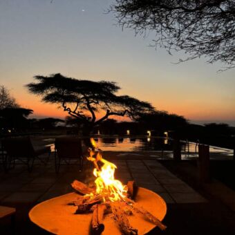 kampvuur met daarachter het zwembad van Manyara Secrets