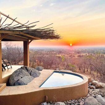 Op een heuvel in Ruaha een plungepool. Ernaast een overdekte veranda met twee stoelen met een geweldig uitzicht bij een ondergaande zon