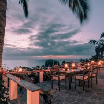 Sfeervolle gedekte tafels met kaarsjes op de veranda bij het Manta Resort Pemba