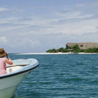 2 gasten in een klein bootje die varen naar een onbewoond eilandje voor de kust van Tanzania onderweg naar hun accommodatie.