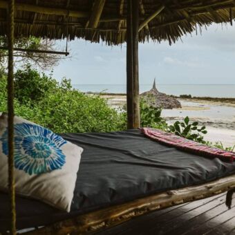 Hangend ligbed op de veranda van een strandaccommodatie met uitzicht op de Indische Oceaan in Tanzania.