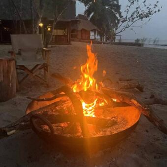 Op het strand in de schemering brand een vuur in een vuurschaal