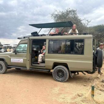 Safariauto met het dak open een kinderen die erin staan