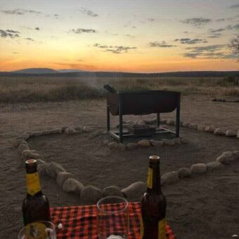 Op een tafeltje twee flesjes bier bij een zonsondergang in Tanzania