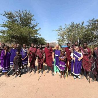 Groepsfoto met de masai en de twee vrouwen die hier op bezoek waren. Zij hebben ook de traditionele kleding aan
