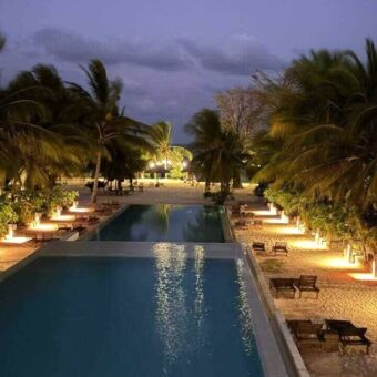 Zwembad met aan de zijkanten allemaal lampen en palmbomen