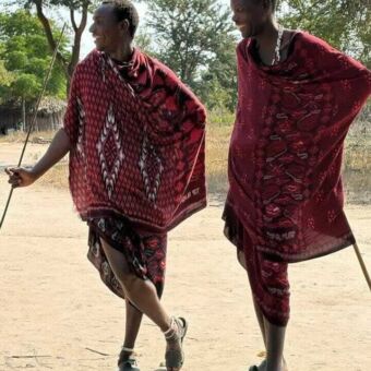 Twee Masai mannen in kleurrijke rode gewaden hebben lol samen