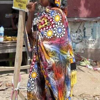 In Stone Town staat een vrouw in een kleurrijk gewaad