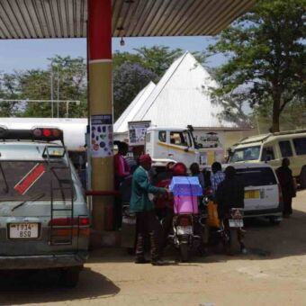 Drukte van auto's, busjes en brommers bij een tankstation