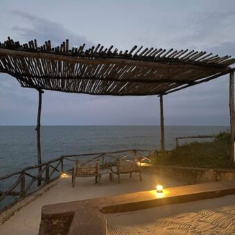 Overkapping met boomtakken bij een lodge in Pangani met uitzicht over de indische oceaan