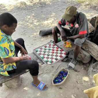 twee mannen die een spelletje dammen spelen op straat in Tanzania