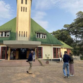 Man met zijn zoon en dochter bij een kerk in Tanzania