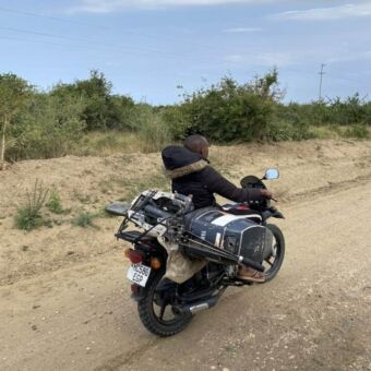 Jongen op een brommer met daarachter op een hele grote brede koffer