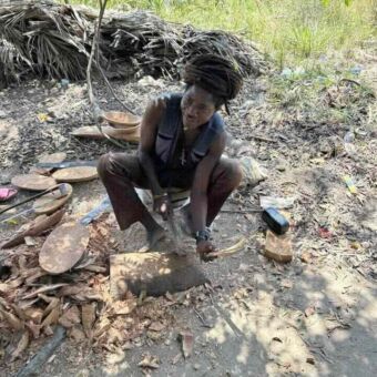 Man zittend die houten schalen aan het maken is
