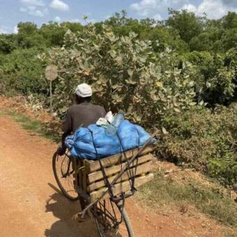 Fietsende man met heel veel spullen achterop de pakjesdrager