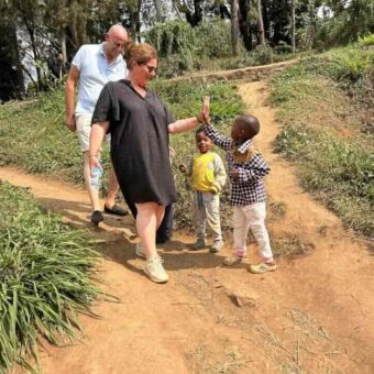 man en vrouw lopen over een zandpad en doen een high five met twee kinderen
