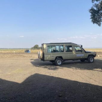 op een zandweg de safari auto van droomreis Tanzania