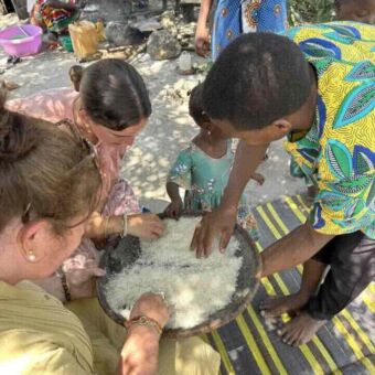 twee vrouwen en jongen en klein kindje die een maaltijd aan het bereiden zijn