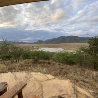 Veranda hooggelegen bij een lodge in Mkomazi met uitzicht over het landschap en waterpoel