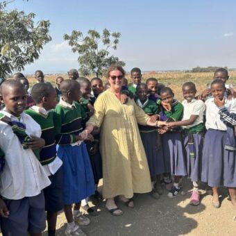 Groep school gaande kinderen met een vrouw er tussen in