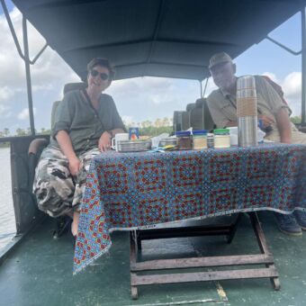 bootsafari waarbij een man en vrouw op een stoeltje zitten achter een tafel met koffie