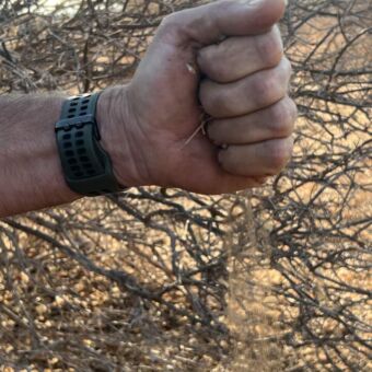 hand van man die as langzaam loslaat om te zien waar de wind vandaan komt