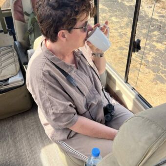 koffiedrinkende vrouw in de safariauto