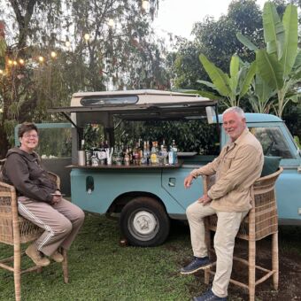 Borrelende man en vrouw bij een defender die omgebouwd is als bar