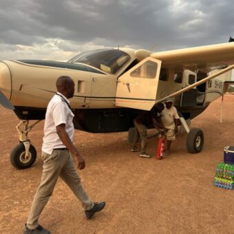 piloot loopt voor zijn kleine chesna vliegtuig op een airstrip in Tanzania
