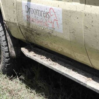 De modderige zijkant van een Droomreis Tanzania Land Cruiser na een avontuurlijke rit.
