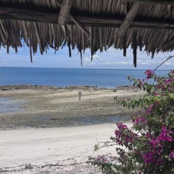 Uitzicht vanuit de Lodge bij Lazy Lagoon uitkijkend naar een man die op de rotsen loopt
