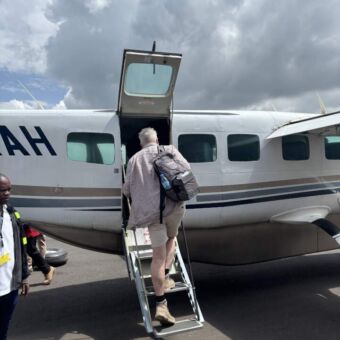 Vliegtuigje waar een man op de trap staat een instapt