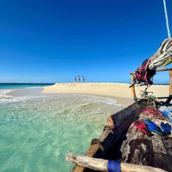 Uitzicht vanuit een houten bootje met snorkeluitrusting op een idyllisch wit zandstrand ivoor de kust van Zanzibar